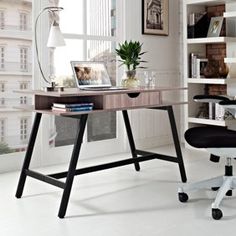 a desk with a laptop on it in front of a window and bookshelves