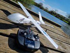 a remote control airplane sitting on top of a wooden dock