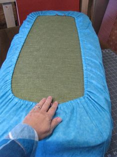 a person is placing the fabric on top of an ottoman cover to make it look like they have been made into a bed