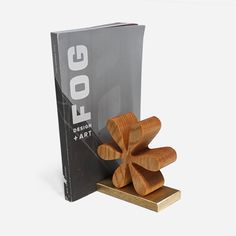 a wooden object sitting on top of a table next to a book holder and cover