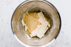 a metal mixing bowl filled with batter and butter