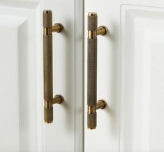 two brass handles are on the white doors