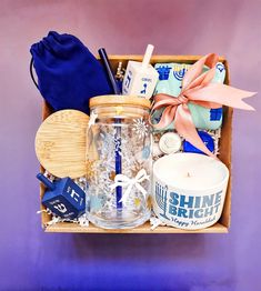 a wooden box filled with assorted items on top of a purple wall next to a blue bag