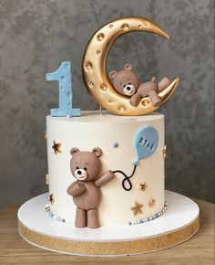 a birthday cake with a teddy bear on top and the number one in the middle