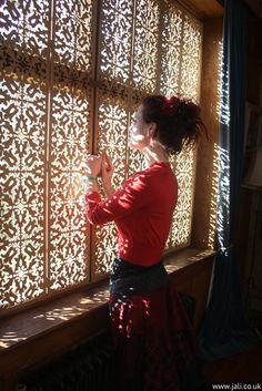 a woman standing in front of a window