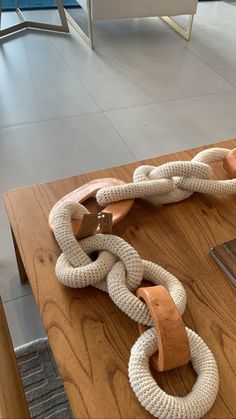 a wooden table topped with a white and brown rope on top of it's side