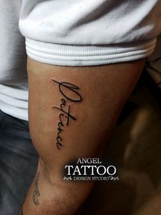 a man with a tattoo on his arm that reads, angel tattoo design studio in cursive font