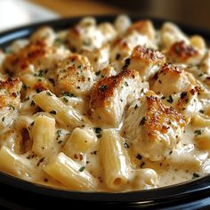 macaroni and cheese with chicken in a black bowl