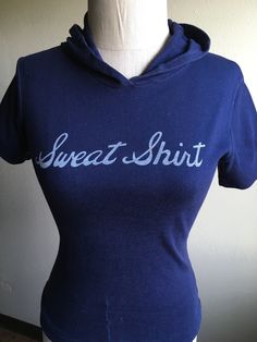 "1970s hooded short sleeve sweatshirt dark blue w/faded cursive lettering repaired at waist hem draw string waist worn in, small holes throughout soft and faded tag unreadable feels cotton, poly, or blend no size tag, measures most like an xxs/xs, flat, shoulder-13 1/2\" chest-16 (to 19) sleeve-6 1/2 length-22 1/2" Blue Long Sleeve Retro Hoodie, Blue Vintage Hoodie With Drawstring Hood, Blue Vintage Cotton Sweatshirt, 70s Shorts, Blue Soft-washed Short Sleeve T-shirt, Blue Soft-washed Hooded Sweatshirt, Short Sleeve Hoodie, Cocktail Dress Vintage, Levis Denim