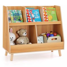 a wooden toy book shelf with books and stuffed animals on the bottom shelf, against a white background