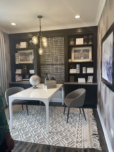 a white table sitting in the middle of a living room next to a book shelf