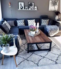 a living room with blue couches and pictures on the wall above them, along with a coffee table