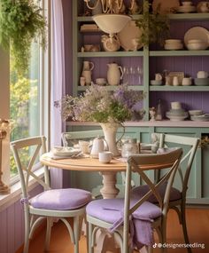 a dining room table with purple chairs next to a window and shelves filled with dishes