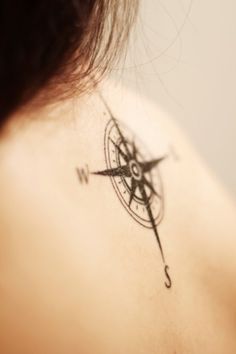 a compass tattoo on the back of a woman's neck