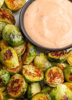 the brussel sprouts are next to a bowl of dip