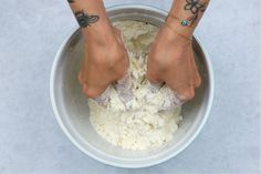 two people standing in a bowl with their feet on top of the bowl and one has tattoos on her arm