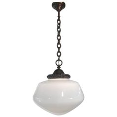 a white light hanging from a chain on a ceiling fixture with an oval glass shade