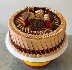 a large chocolate cake sitting on top of a white and yellow plate with strawberries