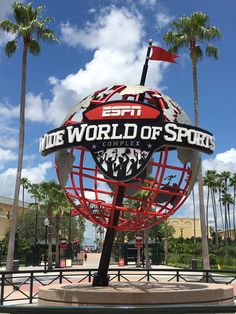 the entrance to espn's world of sports in palm trees and blue sky with clouds