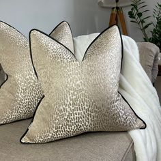 two pillows sitting on top of a couch