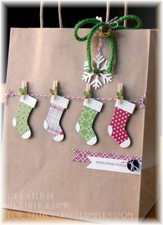 a brown paper bag with christmas stockings and snowflakes hanging from it's handles