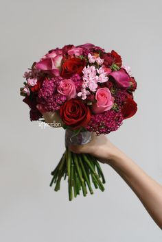 a person holding a bouquet of flowers in their hand