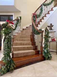 a staircase decorated for christmas with garland and poinsettis