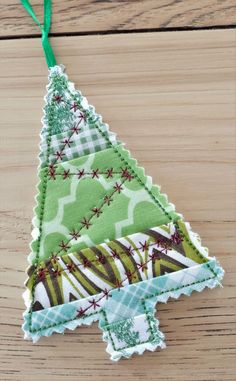 a green christmas tree ornament hanging on a wooden table