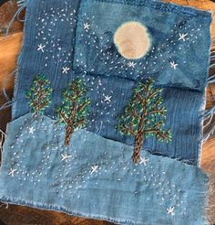 a piece of cloth with trees on it and the moon in the sky above them