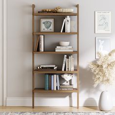 a bookshelf with many books on it in a living room next to a vase