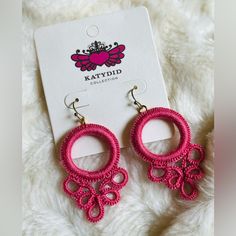 a pair of pink earrings sitting on top of a white blanket