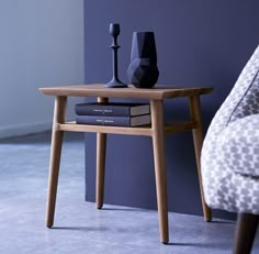 a wooden table with two vases on top of it next to a book shelf