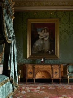 an ornate bedroom with green walls and paintings on the wall