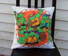 a pillow with teenage mutant turtles on it sitting on a chair in front of a house