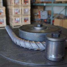 a metal object sitting on top of a table in a room filled with boxes and other items