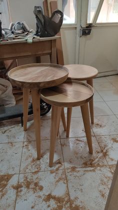 three wooden tables sitting on top of a white tile floor next to a window in a room