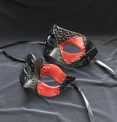 This unique couple's masquerade masks are great for any Venetian mask party or masquerade ball. the women and men's masks are hand painted black and red with raised detail.   Masks are light weight and have a comfortable fit. They also come with black silk ribbon ties attached. Black Masquerade Mask For Cosplay And Mardi Gras, Black Masquerade Mask For Carnival Cosplay, Black Masks For Cosplay Carnival, Black Mardi Gras Cosplay Masks, Black Mask For Cosplay Carnival, Black Venetian Masquerade Mask For Carnival, Black Venetian Mask For Carnival, Black Masquerade Mask For Halloween Gift, Black Venetian Mask For Masquerade