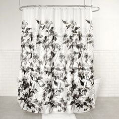 a black and white photo of a shower curtain in a bathroom with tile flooring