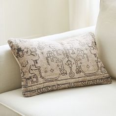 a white couch with a decorative pillow on it