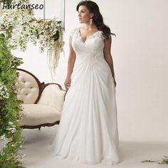 a woman standing in front of a mirror wearing a wedding dress