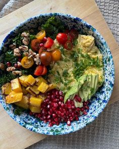 a blue and white bowl filled with food on top of a wooden cutting board