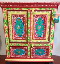 an ornate painted cabinet on display in a room