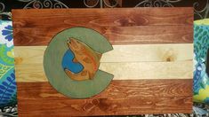 a wooden sign with the letter c painted on it's side and an image of a dog