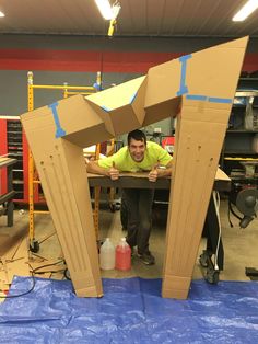 a man sitting at a table made out of cardboard