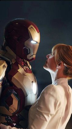 a woman standing next to an iron man