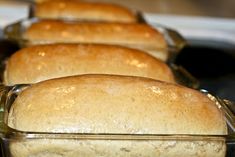 several loafs of bread sitting in pans on a stove top, ready to be baked