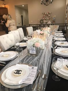 a long table with white plates and silverware is set for an elegant dinner party