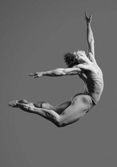 a man in the air doing a trick on a skateboard with his feet up