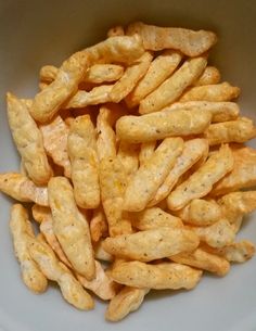 a white bowl filled with cheetos sitting on top of a table