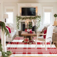 a living room decorated for christmas with red and white decor